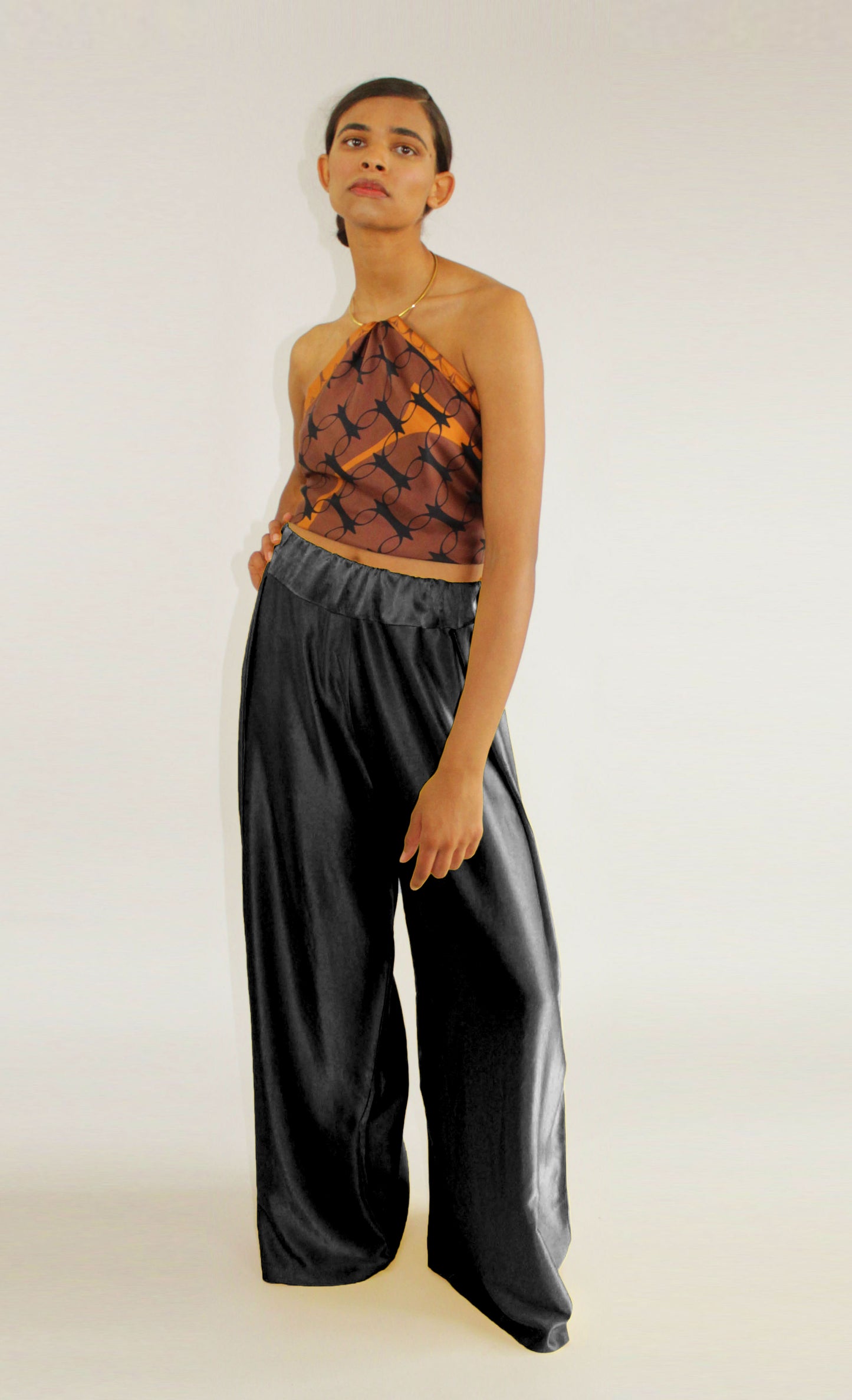 Black silk palazzo trousers by COLUCCI, crafted from premium crepe silk satin with a high-waisted, flat-front silhouette and discreet side elastic waistband for comfort and elegance.
