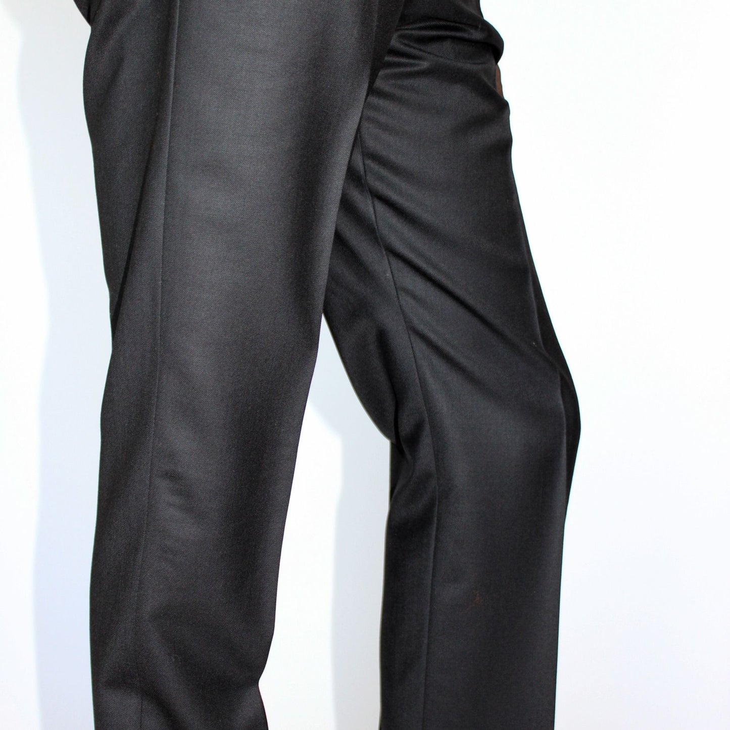 High-waisted tapered trousers by COLUCCI, expertly crafted by a Savile Row tailor from luxurious superfine merino wool with natural stretch. Featuring side adjusters for a perfect fit and a versatile jet-black hue, suitable for both office and casual wear.