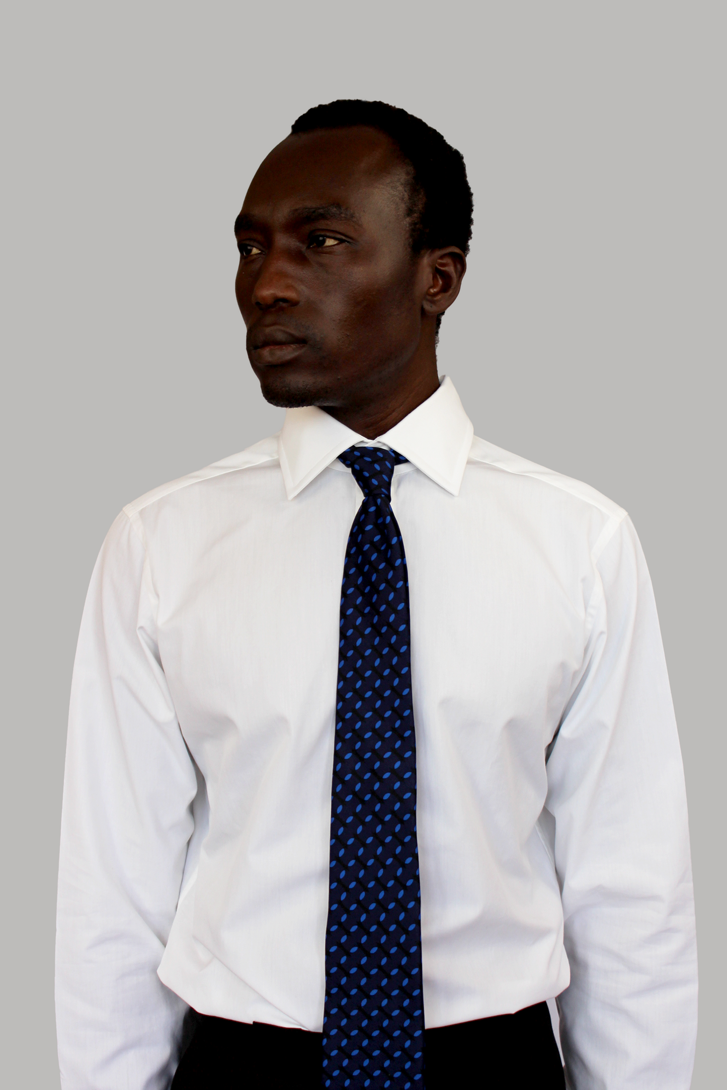 Shirt with a wide cutaway collar, concealed placket, and unique concealed buttons on the collar and cuffs, crafted from mother of pearl for a luxurious touch. Made-to-order by our bespoke Savile Row tailor, ensuring a perfect fit and modern flair in a classic silhouette.