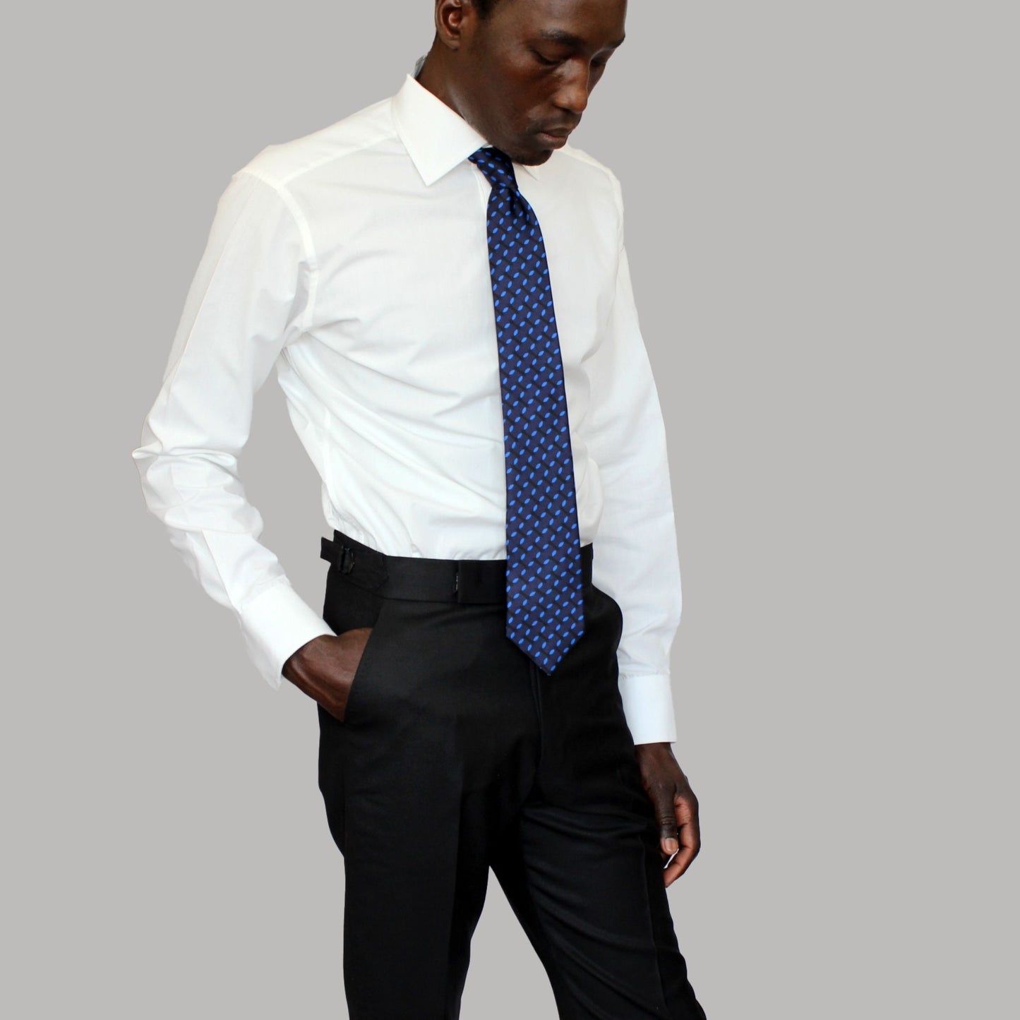 High-waisted tapered trousers by COLUCCI, expertly crafted by a Savile Row tailor from luxurious superfine merino wool with natural stretch. Featuring side adjusters for a perfect fit and a versatile jet-black hue, suitable for both office and casual wear.