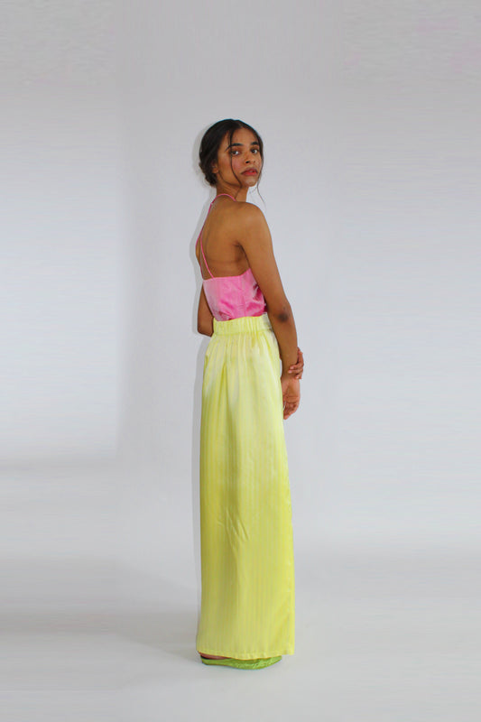 Palazzo trousers by COLUCCI, inspired by 1930s beach pyjamas, featuring a wide draping leg, high-waisted flat-front silhouette, and discreet side elastic waistband for comfort. Available in three eye-catching colors, crafted from designer deadstock fabrics for day-to-night elegance.