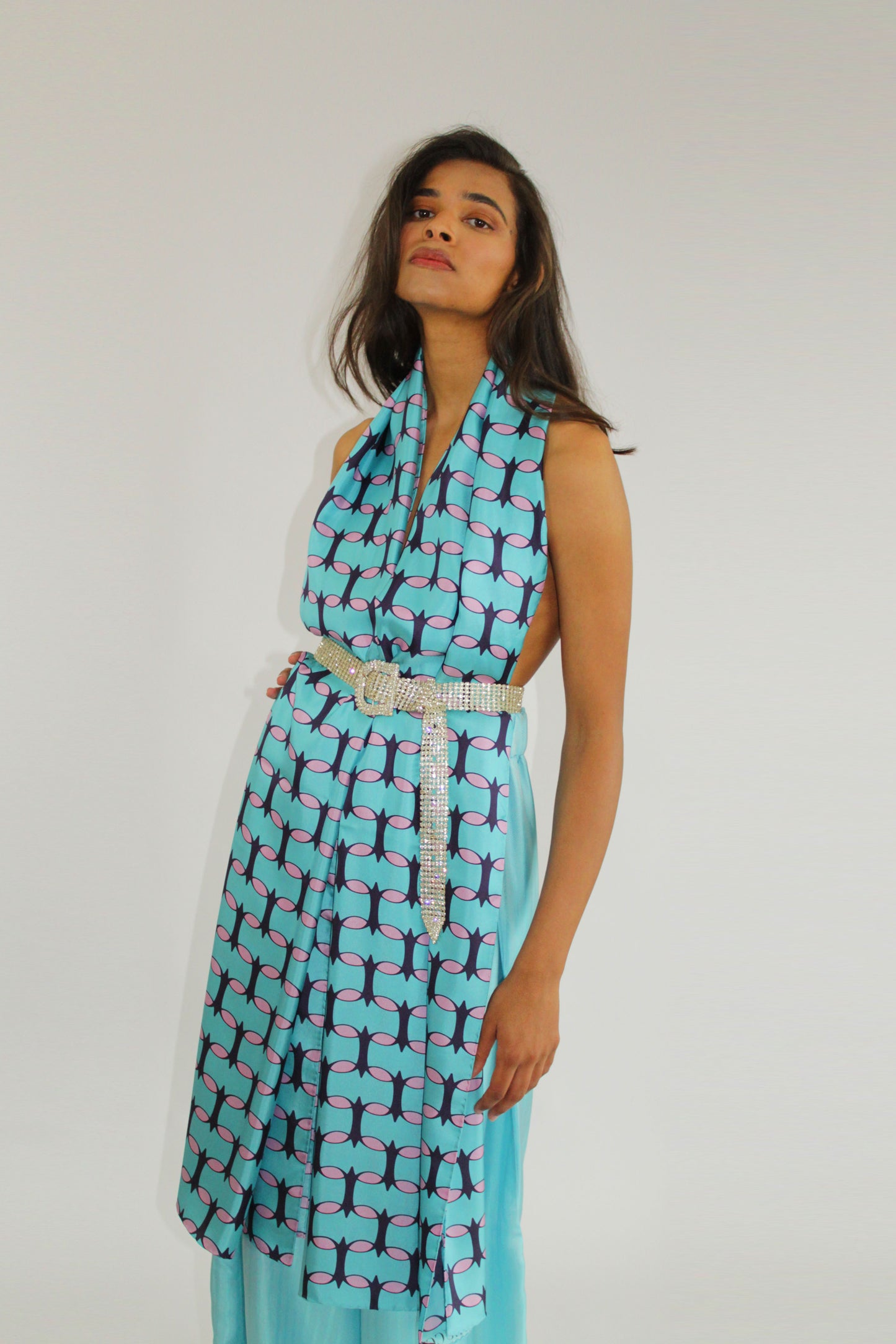 Teal and pink monogram silk shawl by COLUCCI, hand-rolled and printed in Macclesfield. This extra-long, limited-edition shawl offers versatile styling and a touch of drama, reflecting a commitment to sustainable fashion with minimized overproduction.