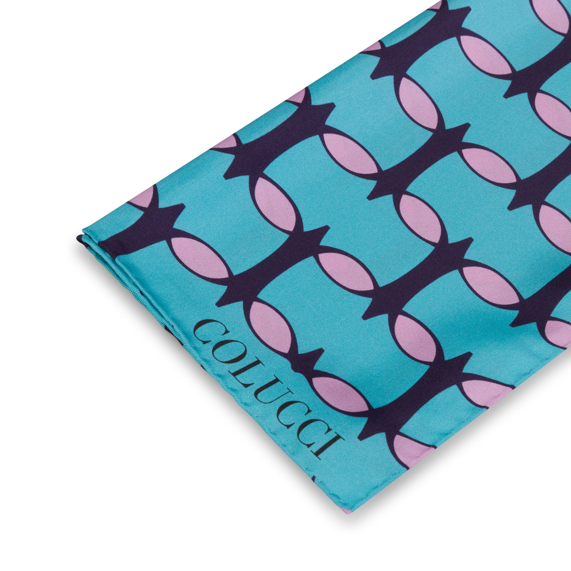 Teal and pink monogram silk shawl by COLUCCI, hand-rolled and printed in Macclesfield. This extra-long, limited-edition shawl offers versatile styling and a touch of drama, reflecting a commitment to sustainable fashion with minimized overproduction.