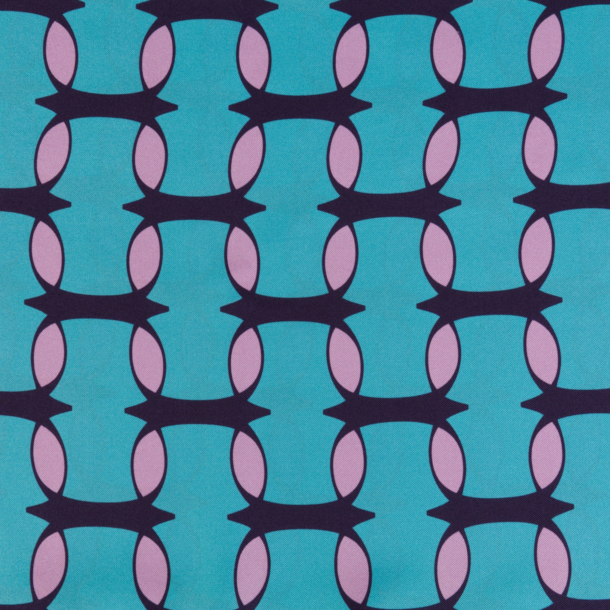 Teal and pink monogram silk shawl by COLUCCI, hand-rolled and printed in Macclesfield. This extra-long, limited-edition shawl offers versatile styling and a touch of drama, reflecting a commitment to sustainable fashion with minimized overproduction.