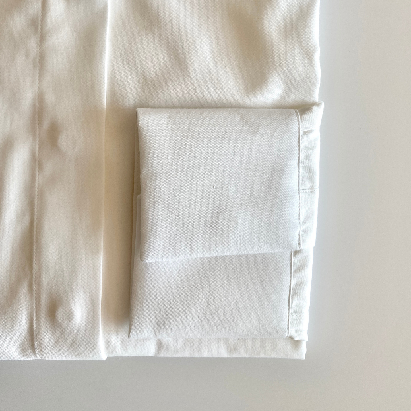 White dress shirt for women by COLUCCI, featuring a wide cutaway collar and concealed placket for refined sophistication. Unique concealed buttons on the collar and cuffs add modern flair, with each button crafted from mother of pearl for a luxurious touch. Made-to-order by our Savile Row tailor, ensuring a perfect fit tailored to the customer’s measurements.