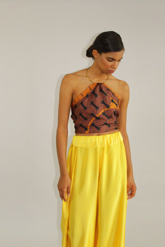 Yellow silk palazzo trousers by COLUCCI, crafted from premium crepe silk satin for luxury. Featuring a high-waisted, flat-front silhouette and discreet side elastic waistband for comfort and a flattering fit. Versatile for day-to-night styling, pair with a casual tee and sandals or a blouse and heels for a refined look. A luxurious wardrobe staple blending elegance and versatility.