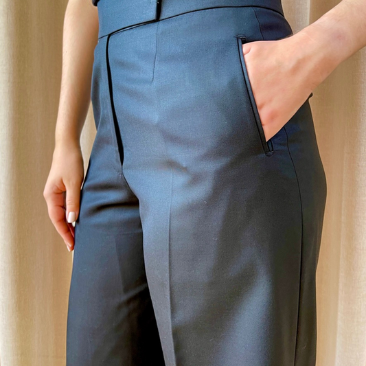 High-waisted wide-leg trousers by COLUCCI, expertly crafted by a Savile Row tailor from luxurious superfine merino wool with natural stretch. The jet-black hue ensures versatility, perfect for pairing with a crisp shirt, chunky knit, or silky top for various occasions. A refined staple combining classic tailoring with modern sophistication.