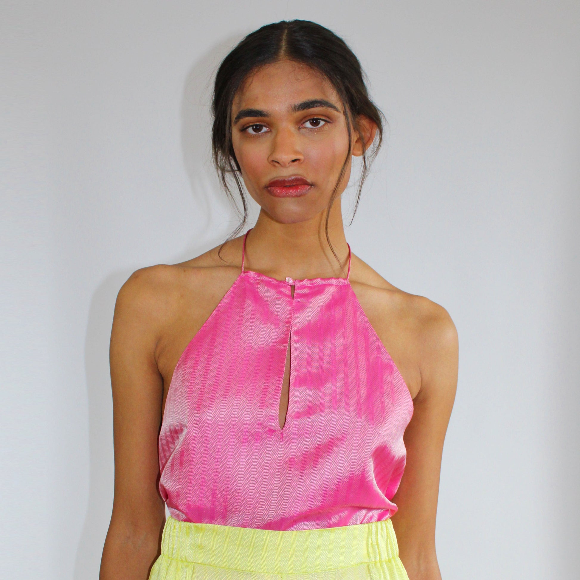 1970s-inspired halter tank top by COLUCCI with a chic keyhole neckline and strappy back, available in three vibrant shades. Made from luxurious deadstock fabrics and meticulously crafted to order in our London studio, offering a unique, high-quality piece.