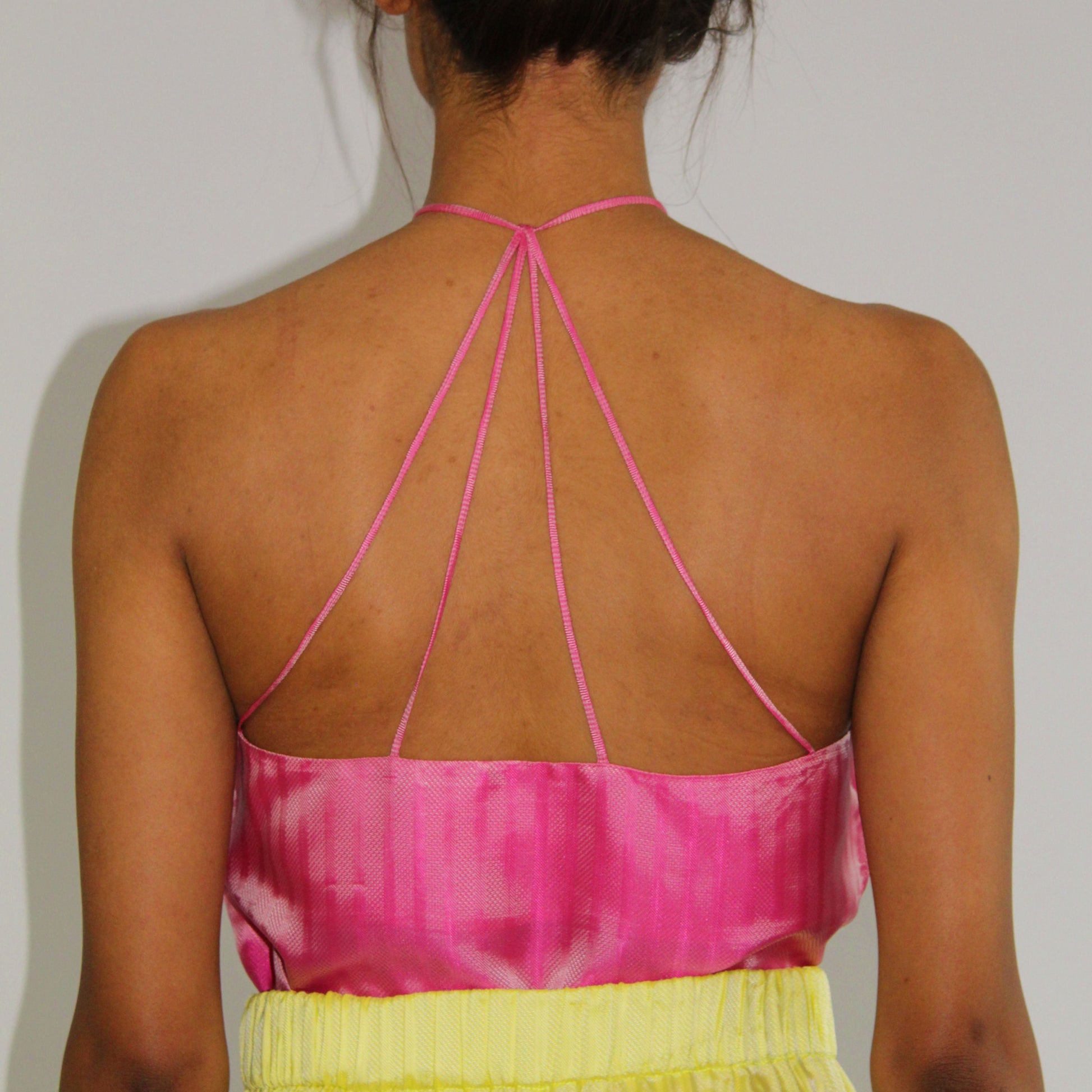 1970s-inspired halter tank top by COLUCCI with a chic keyhole neckline and strappy back, available in three vibrant shades. Made from luxurious deadstock fabrics and meticulously crafted to order in our London studio, offering a unique, high-quality piece.